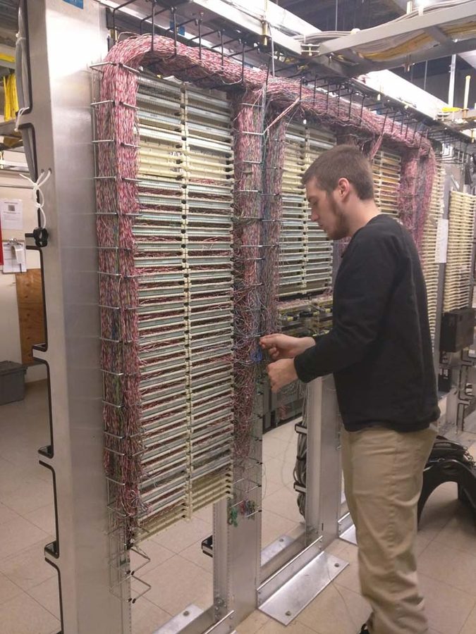 DR TEC technician working on MDF telecom wiring panel in Chicago