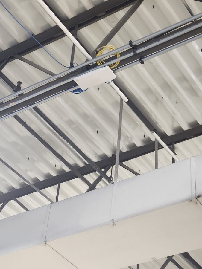 Commercial WiFi access point installed on warehouse ceiling in Chicago